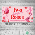 Pink and red girls birthday banner with the wording Two Dozen Roses in a western cowgirl font and rope font for birthday party. Banner has a border of a disco ball, cowgirl hat and boot, cactus, acoustic guitar and roses sprinkled throughout