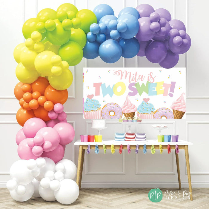Dessert-themed "Two Sweet" birthday banner with rainbow colors, featuring cupcakes, donuts, sprinkles and ice cream cones for a second birthday party.
