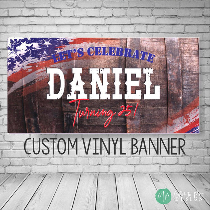A custom vinyl banner with a rustic wood whiskey barrel background and an American flag design. The banner says 'Let's Celebrate name and age!' in white text with red and blue American Flag accents. The banner is a custom vinyl banner for a birthday party.