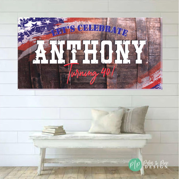 A birthday banner with a wooden whiskey barrel background and red, white, and blue American flag design for a mens birthday. The sign says 'Let's Celebrate Anthony Turning 40!' in white text with red lettering for 'Turning 40!'.