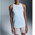 A female model wearing a light blue, sleeveless tank top and beige shorts.