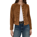 A woman wearing a cropped brown suede jacket with gold-tone decorative buttons down the front, styled over a white top and blue jeans.
